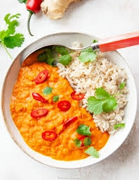 Gulasz curry z czerwonej soczewicy z ryżem i świeżą kolendrą.