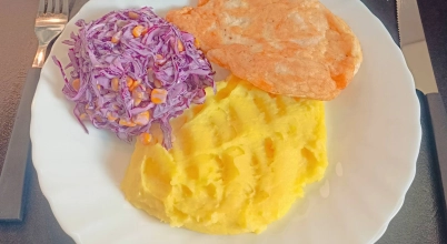 Kotlet z kurczaka oraz puree i surówką z czerwonej kapusty.